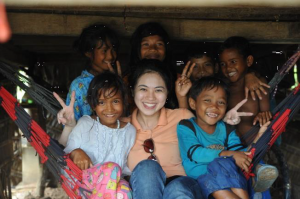 Jacqueline with the village kids at Prey Kabas taking shelter from the rain during a video shoot